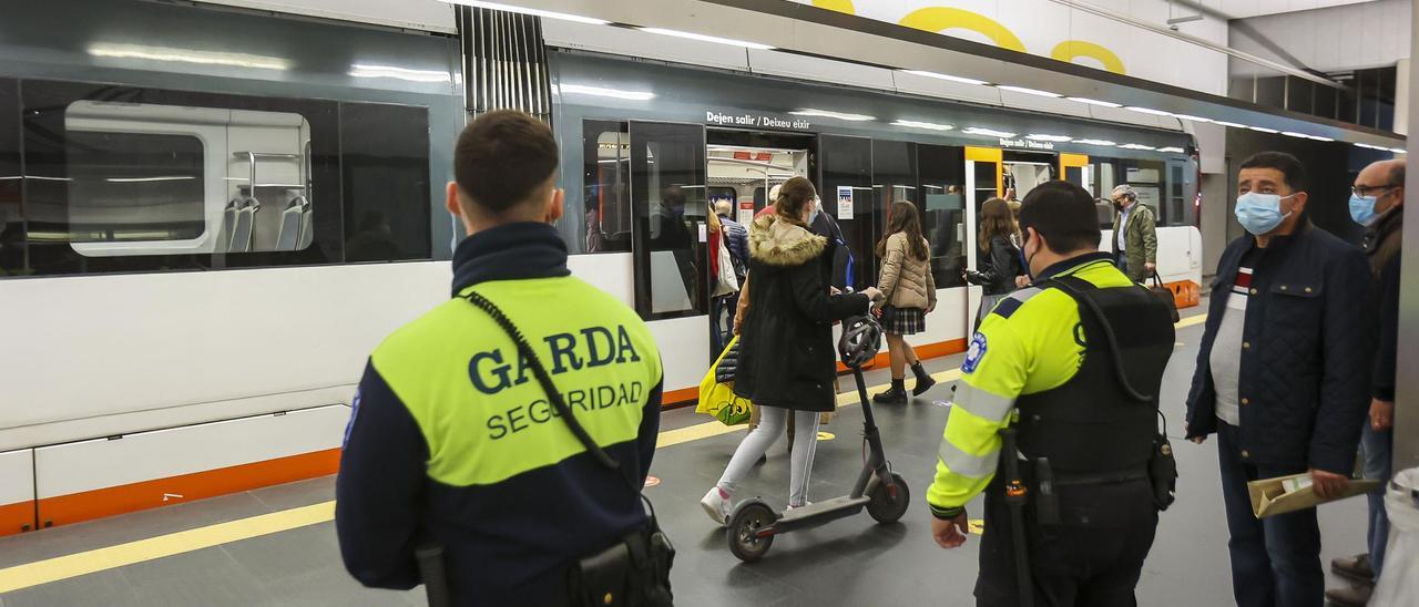 Dos guardas de seguridad vigilan los accesos a los tranvías en la estación de Luceros