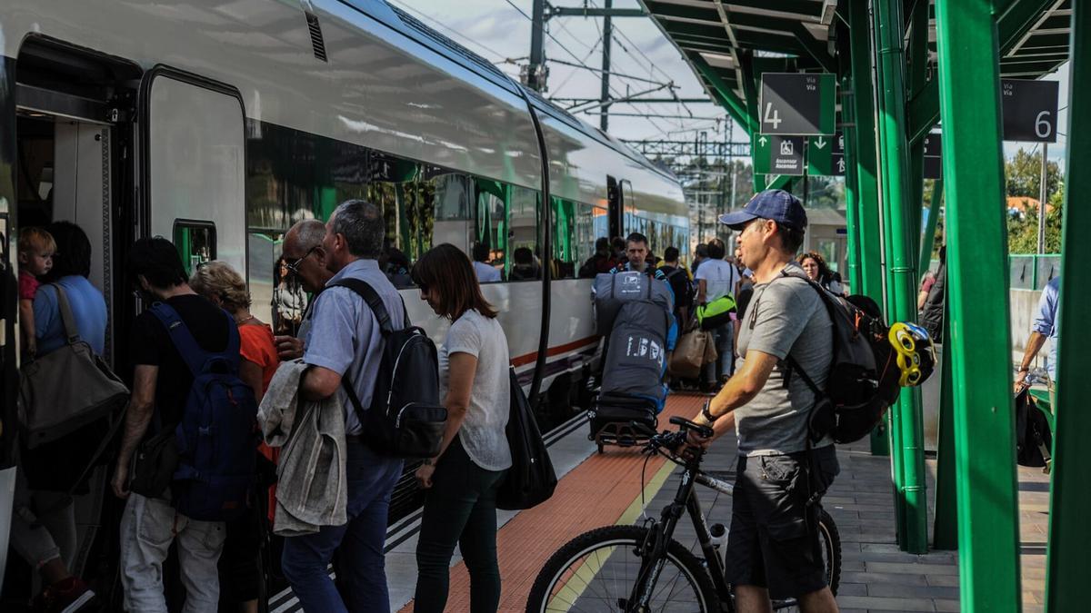 Un pasajero espera con su bicileta para subirse a un tren de Media Distancia en Vilagarcía