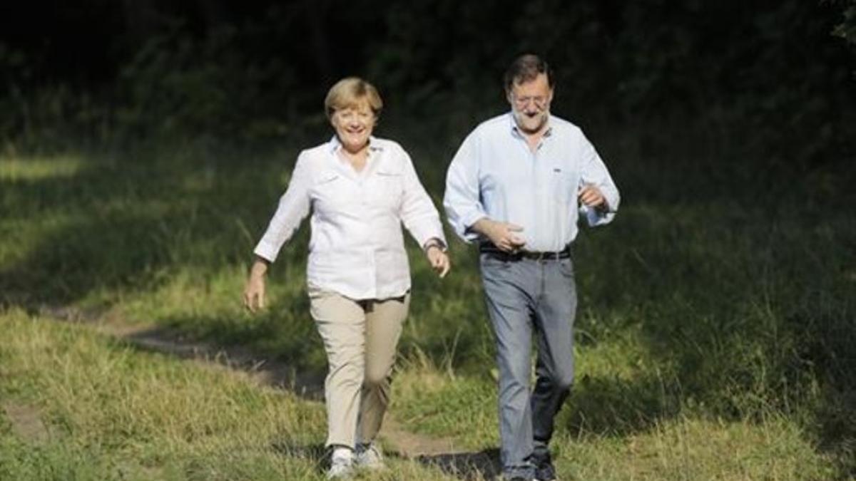 Angela Merkel y Mariano Rajoy pasean ayer por los alrededores del castillo de Meseberg.