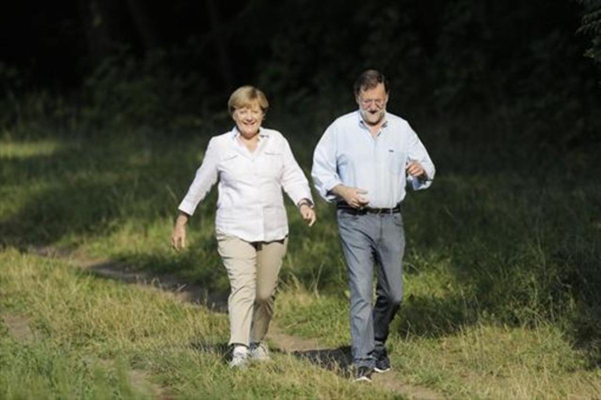 Angela Merkel i Mariano Rajoy passegen pels voltants del castell de Meseberg, ahir.