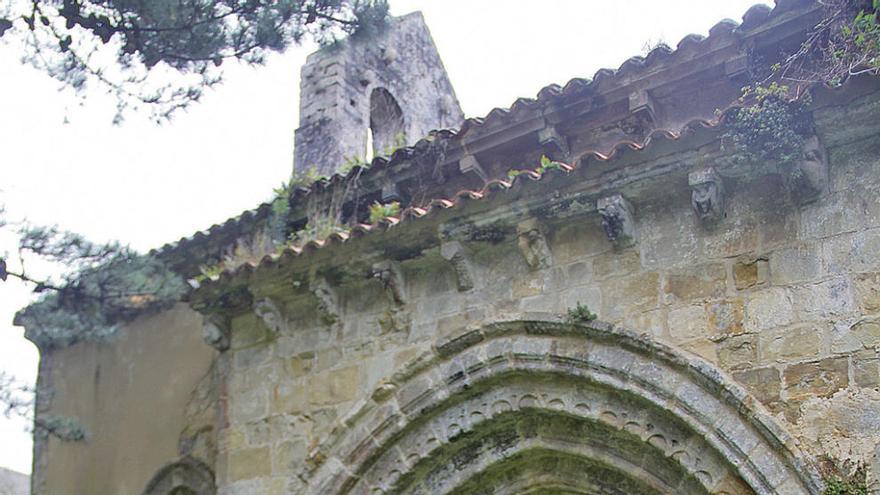 Un hombre junto a la iglesia de Bedón, con una de sus puertas abierta.