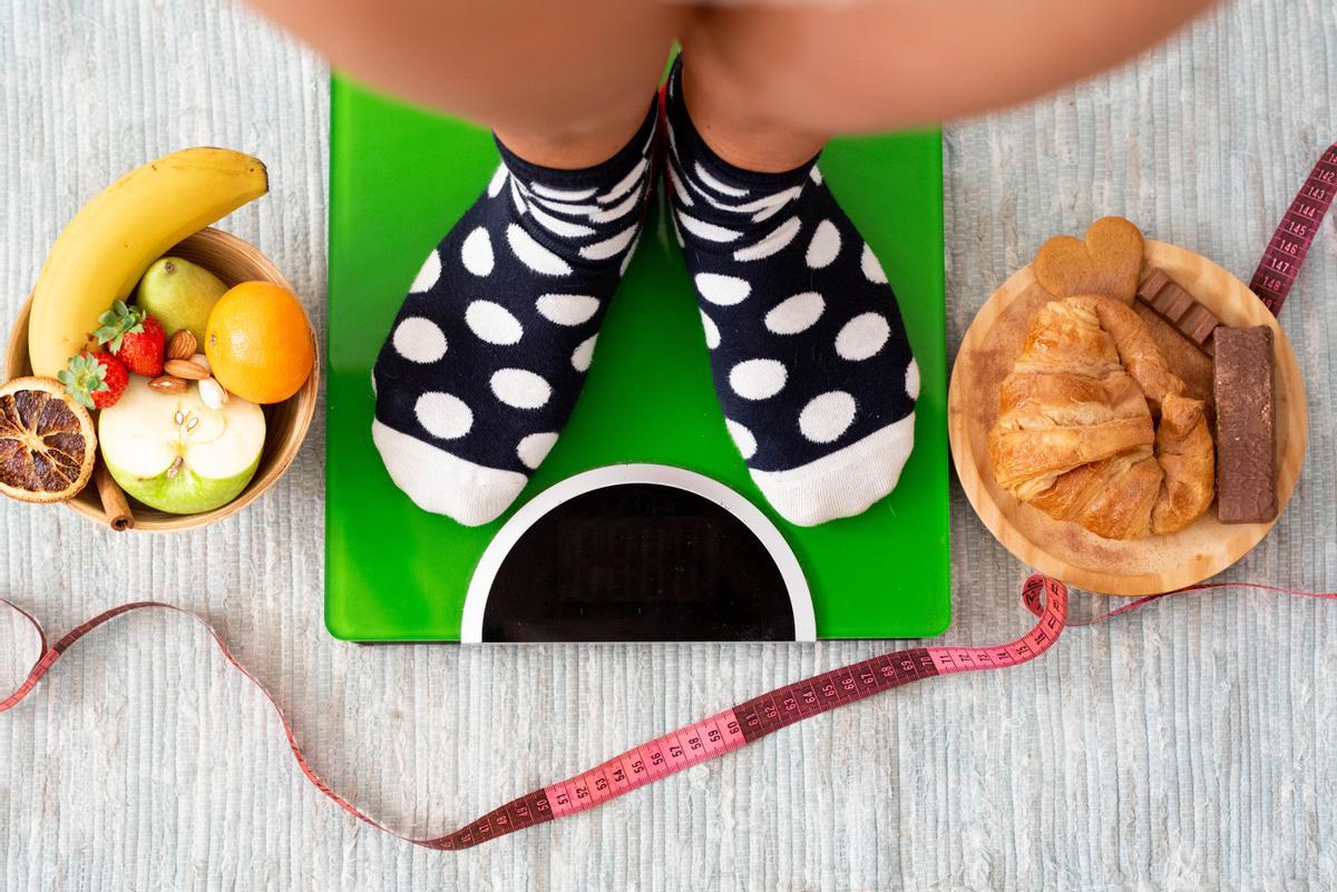 close up and portrait of legs ad feet weighing on a weight scale to see if she has lose weight after a healthy lifestyle eating fruit