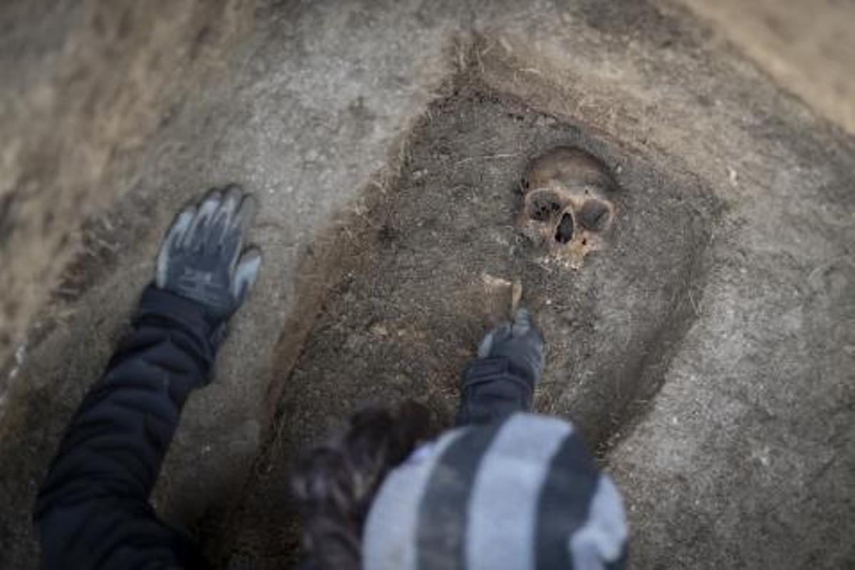 Gracia y Maria José, con una foto de su abuelo, en el cementerio de Celanova, mientras se realizan las labores de exhumación.   | // BRAIS LORENZO