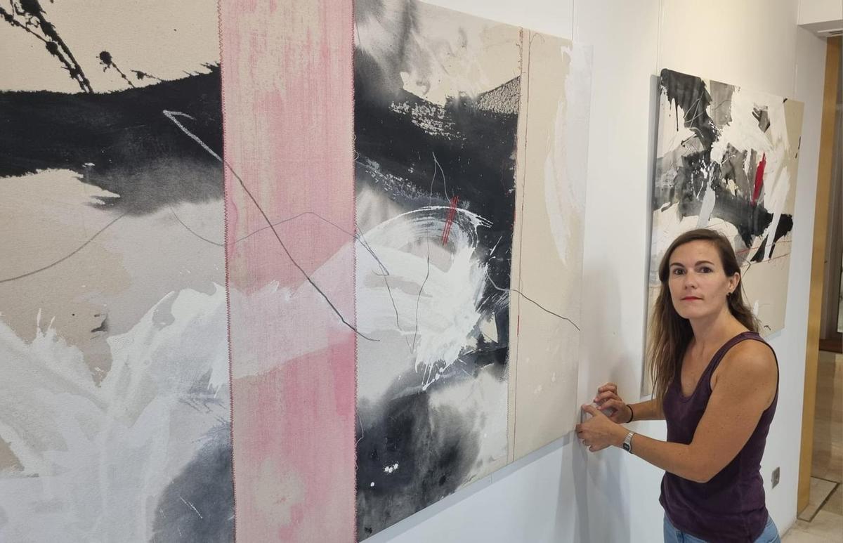 La artista Perceval Graells, junto a algunas pinturas de la exposición "Traces"