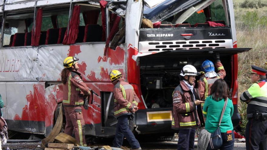 Equips d&#039;emergència revisen l&#039;estat en què va quedar el bus sinistrat diumenge.