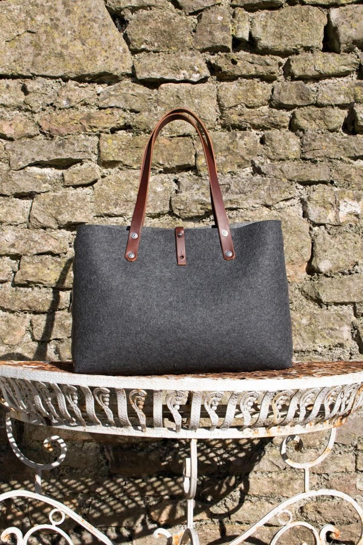 Bolso de fieltro  con asa y cierre de cuero (Precio: 63,14 euros)