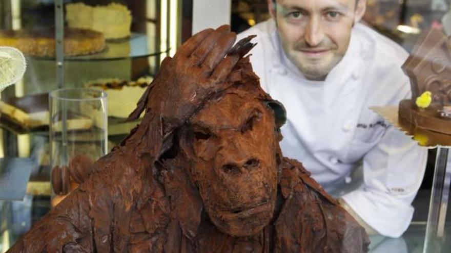 Antonio Argüelles posa tras el escaparate de su confitería con su simio de chocolate.
