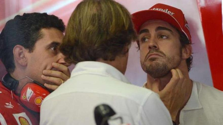 Alonso dialoga con compañeros de su equipo durante la sesión clasificatoria de ayer. / efe / luka zennaro