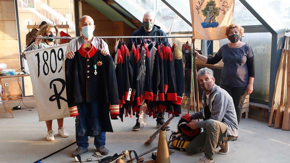 Integrantes de la asociación vecinal llevan un perchero con los  trajes de la Reconquista.