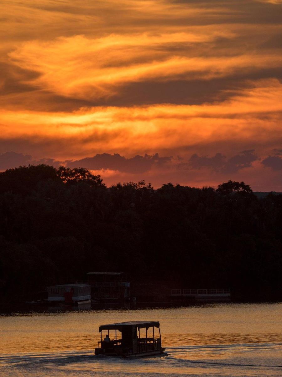 El barco navega en el río Zambeze durante la puesta de sol