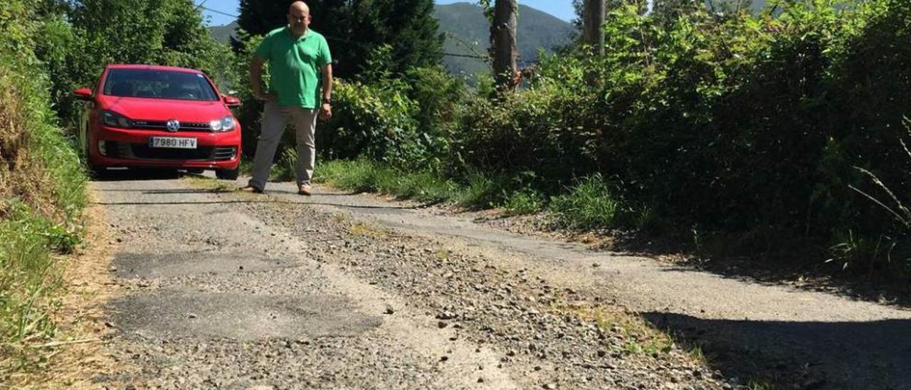 El vecino Roberto García observa el mal estado del camino de Vixili, en San Juan de Parres, ayer.