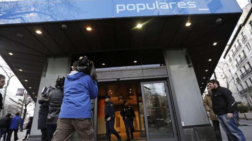 Agentes de la Policía Nacional salen de la sede central del PP, tras la denuncia de Bárcenas.  // Efe