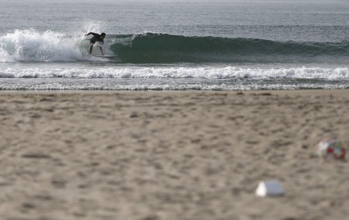 Un surfista llisca sobre les onades a la platja de Toyoma, a 50 quilòmetres de la central nuclear de Fukushima.