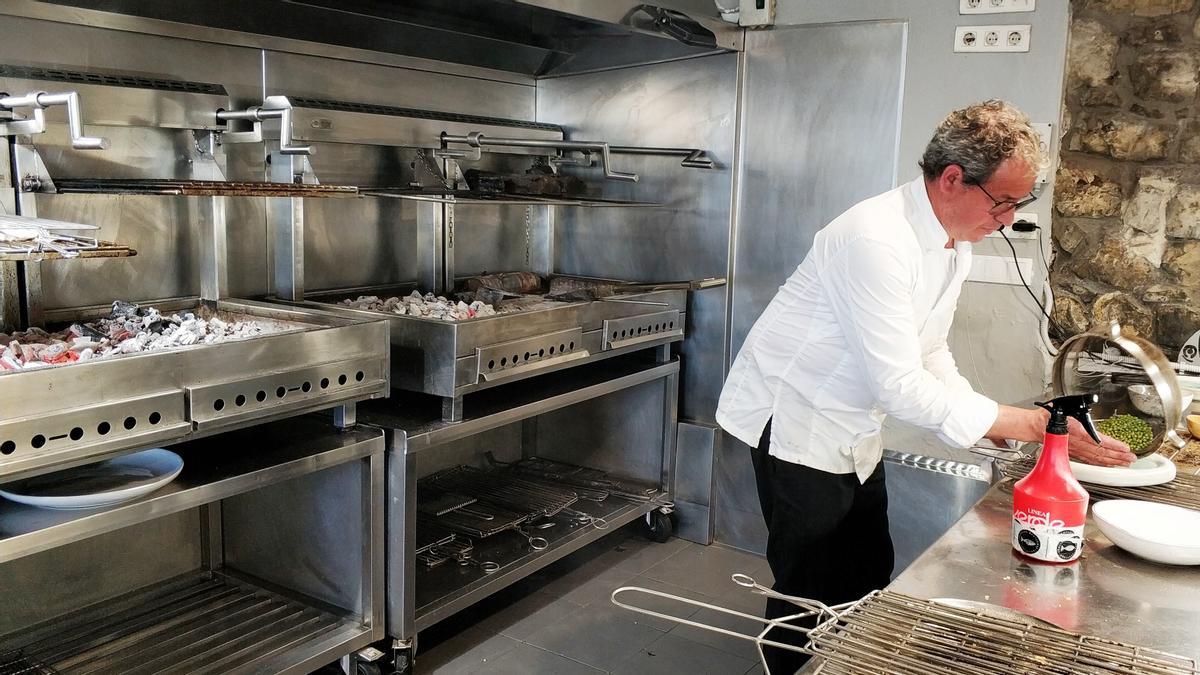 Abel Álvarez, con unos guisantes y la parrilla, detrás.