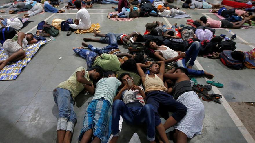 Varias personas duermen en una estación en Odisha tras la cancelación de los trenes.