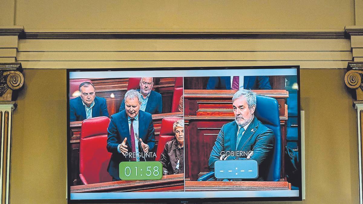 Una de las pantallas del hemiciclo canario muestra, al socialista Sebastián Franquis y a Fernando Clavijo.