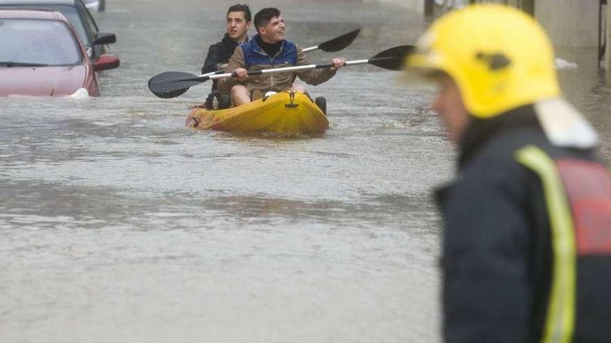 Dos jóvenes en canoa por la zona de As Brañas durante las inundaciones del pasado marzo.