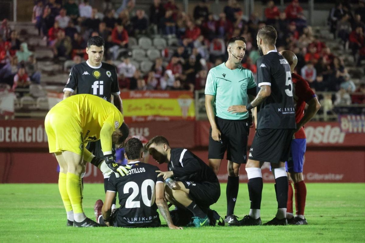 Los compañeros se interesan por Alejandro Sotillos durante el partido en la Nueva Condomina de Murcia.