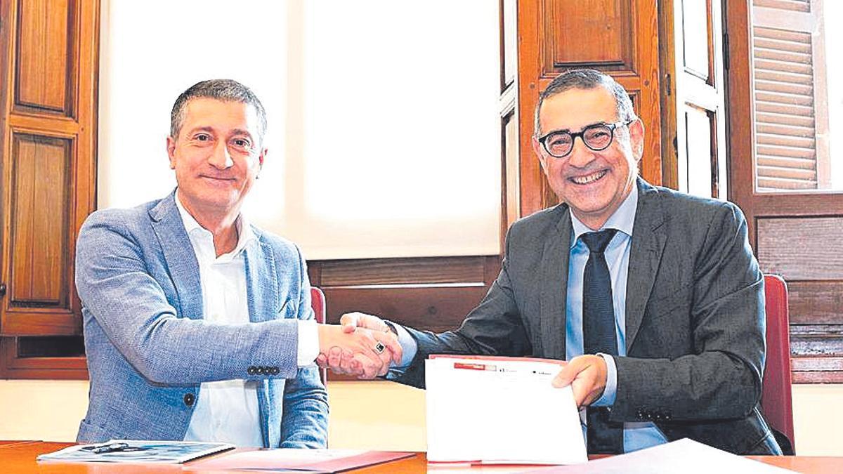 Marcello Busson y el rector José Luján, tras la firma