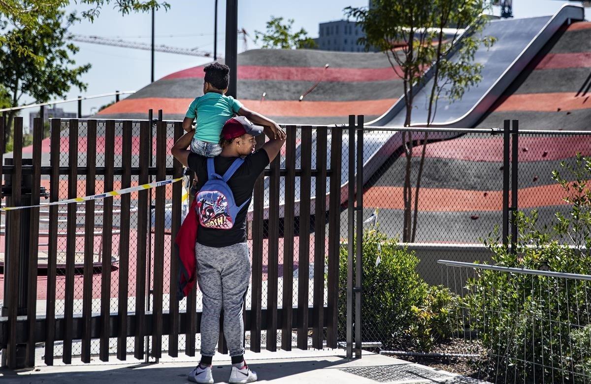 Un padre y su hija observan el recinto del tobogán gigante de Glòries cerrado al público, este mediodía.