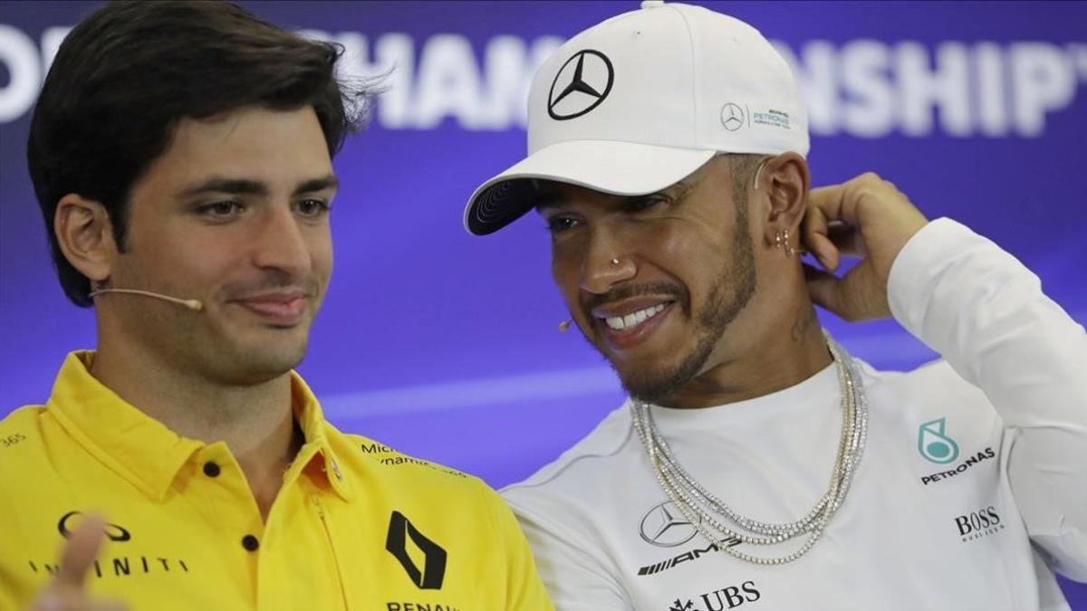 Lewis Hamilton, a la derecha, bromea con Carlos Sainz, entonces (2017), pilotos de Renault.