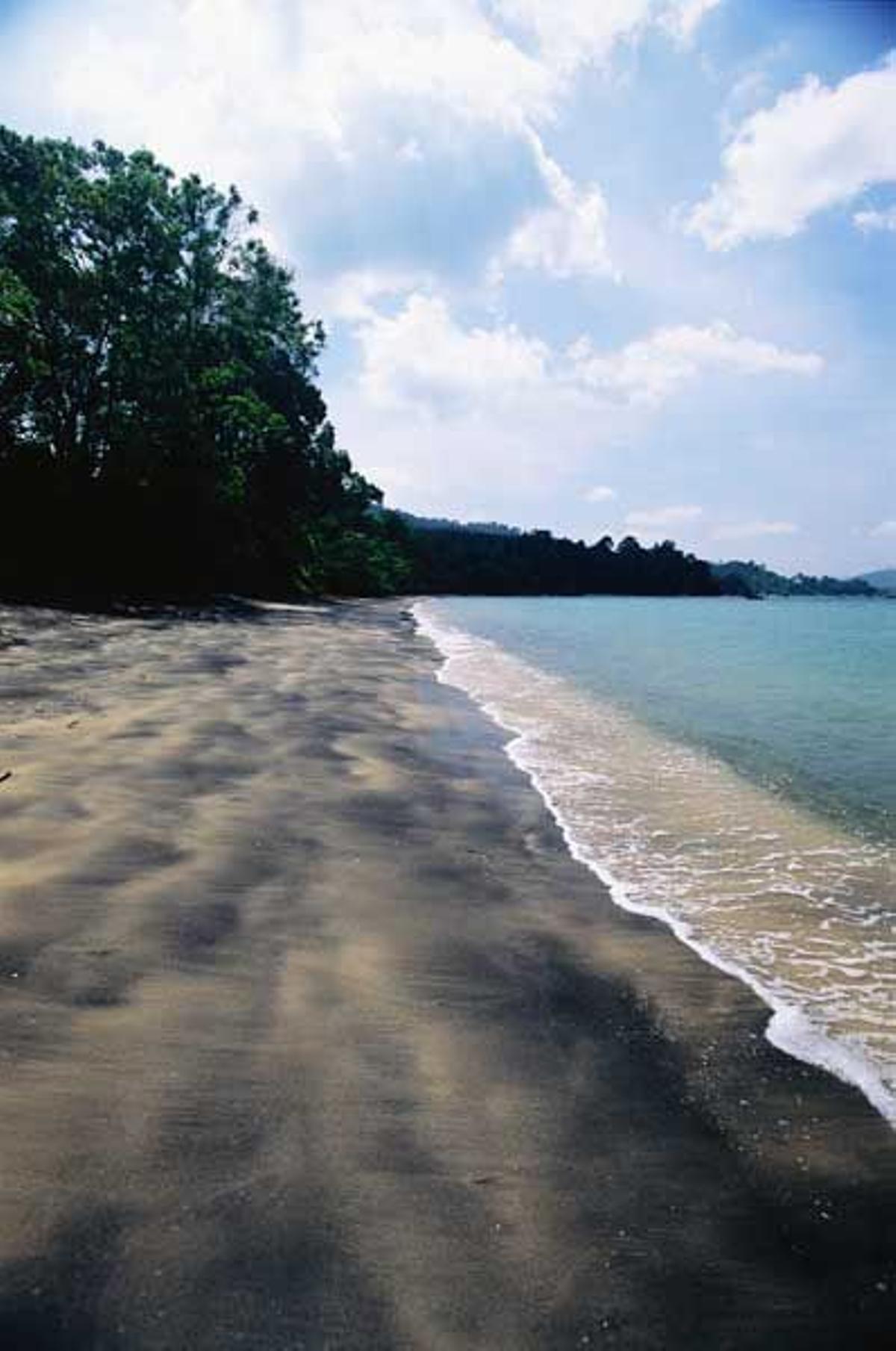 Playa de arena negra Pasi Hitam en Langkawi.