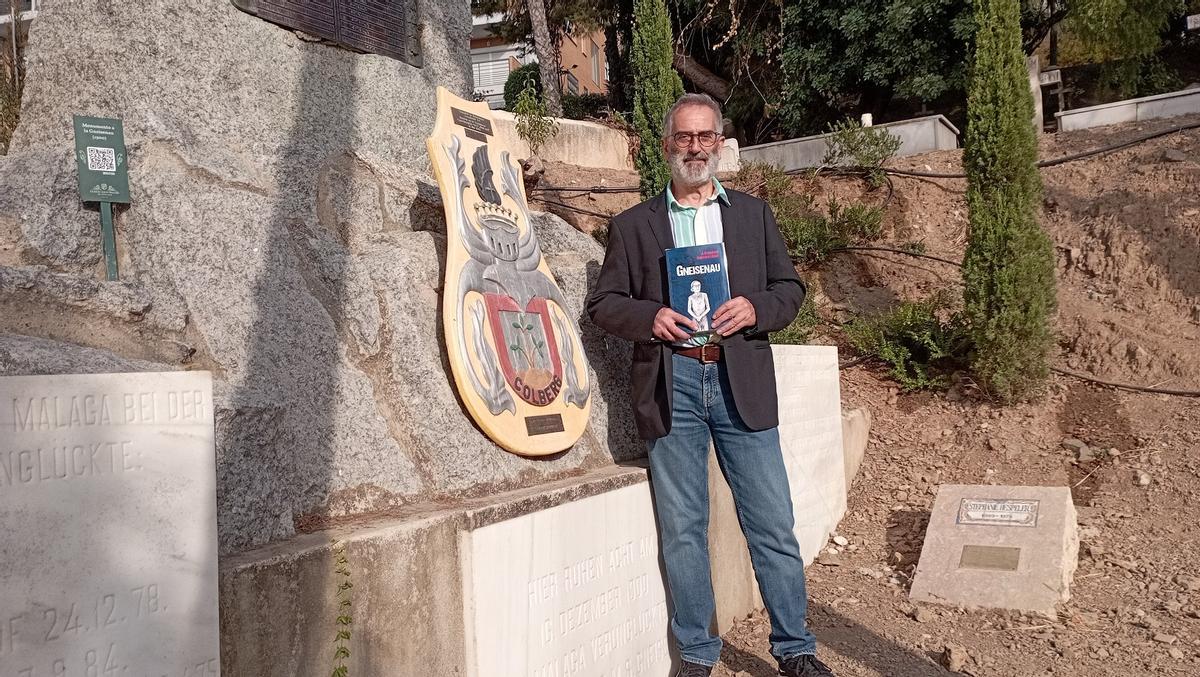 Francisco Guerrero, en el Cementerio Inglés, con su novela, junto al monumento y tumba de los oficiales de la ‘Gneisenau’.