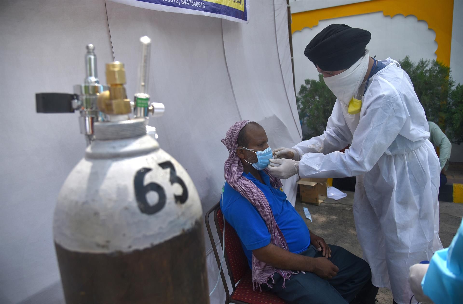 Un sanitario aplica oxígeno a un paciente en Nueva Delhi.