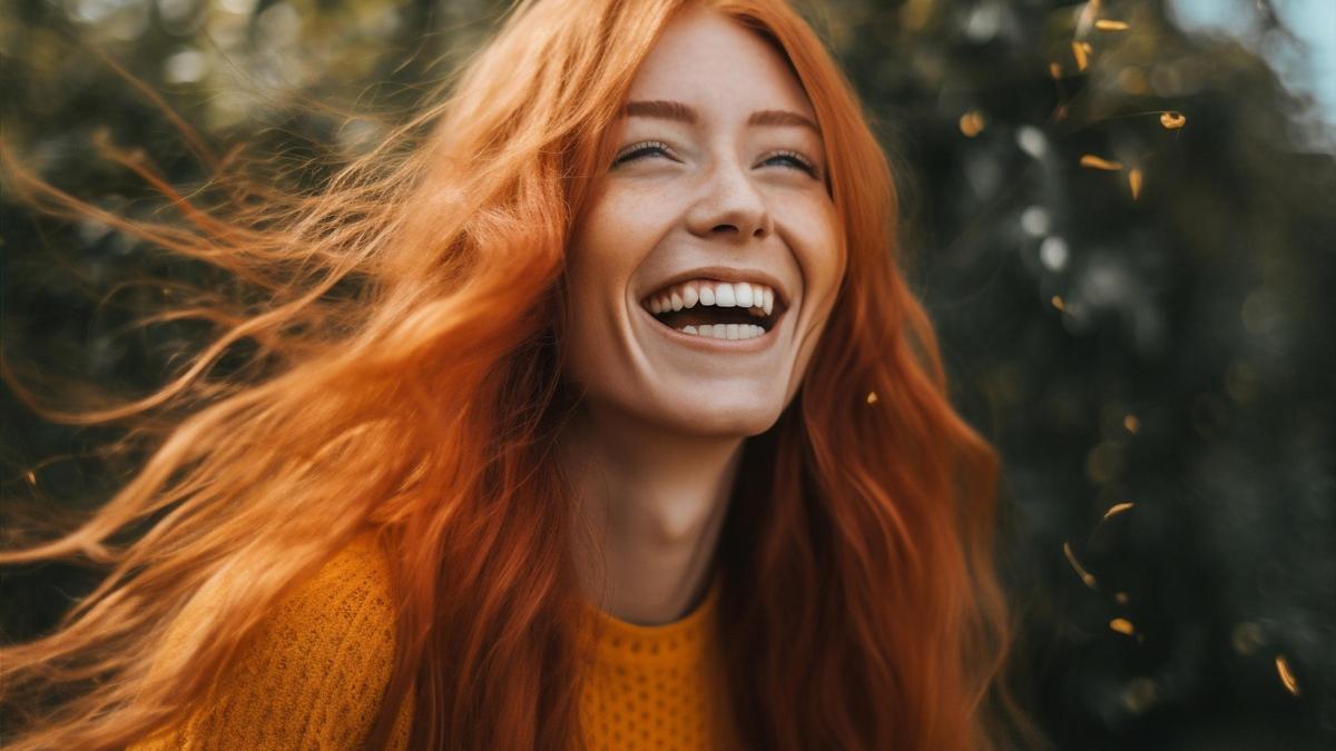 Mujer pelirroja sonriendo.