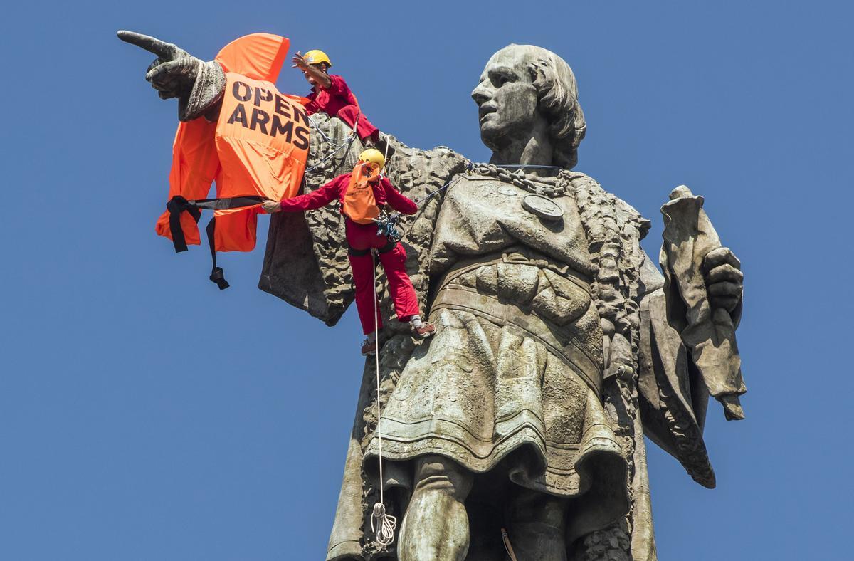 Miembros de Open Arms colocan un chaleco salvavidas en el monumento a Colón, en julio del 2018.