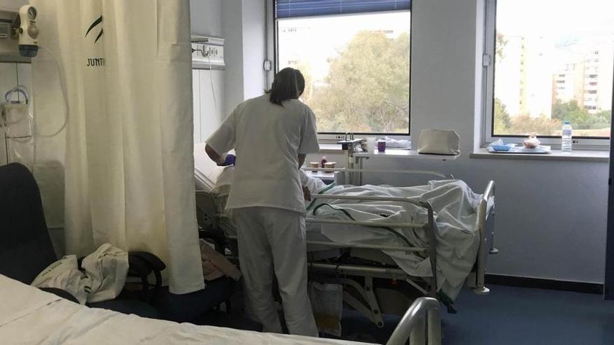 Una enfermera atiende a una paciente en una habitación de un hospital de Málaga.