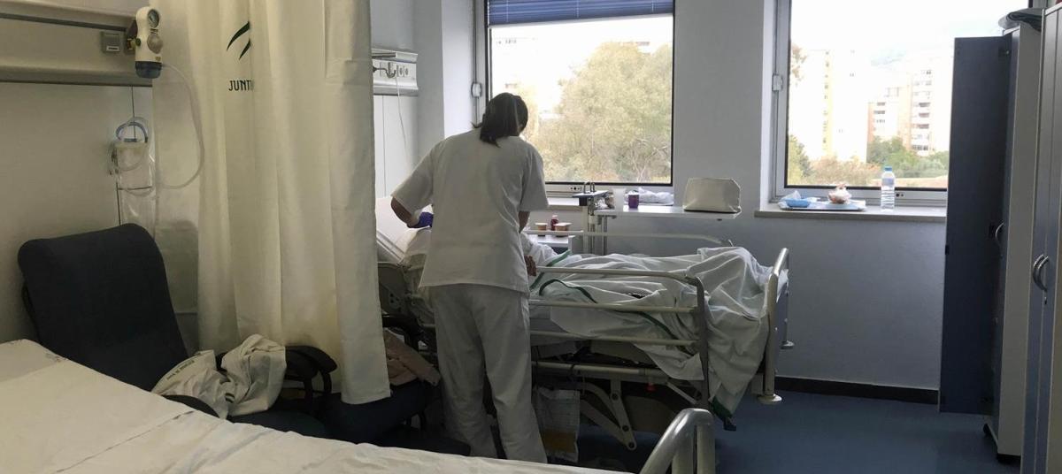 Una enfermera atiende a una paciente en una habitación de un hospital de Málaga.