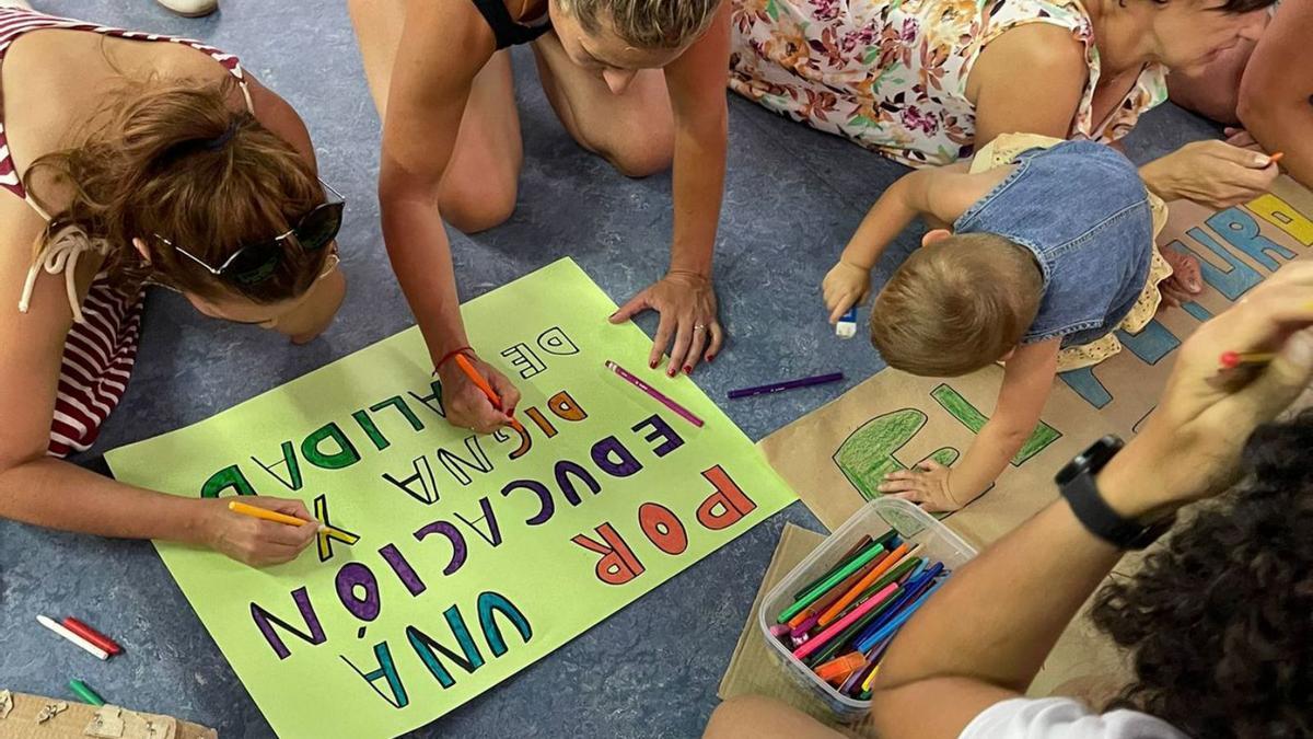 Padres y niños fabrican las pancartas para la manifestación de ayer. | Araceli  Saavedra