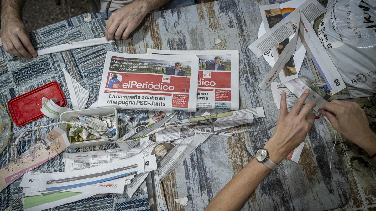 Vecinos de Gràcia, en plena confección de los adornos de la fiesta mayor con papel de El Periódico