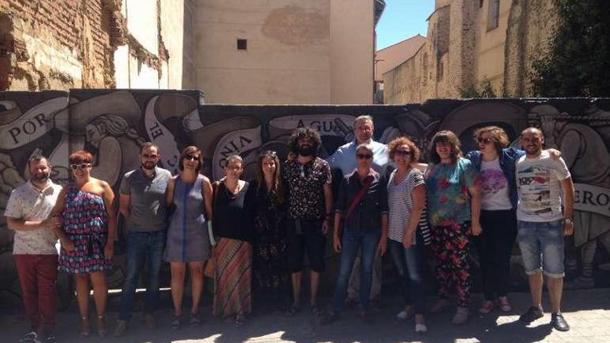 Representantes públicos y voluntarios de TAU frente al mural.