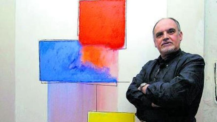 El pintor grancanario posando junto a una de sus obras.
