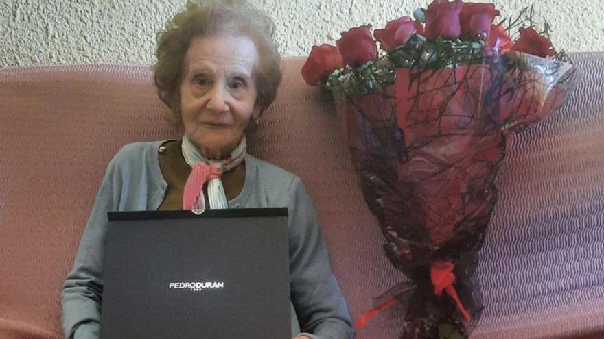 María Carmen con la placa conmemorativa y las flores del consistorio. | SERVICIO ESPECIAL