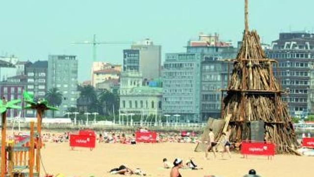 Bañistas, junto a la hoguera de San Juan, en la playa de Poniente.