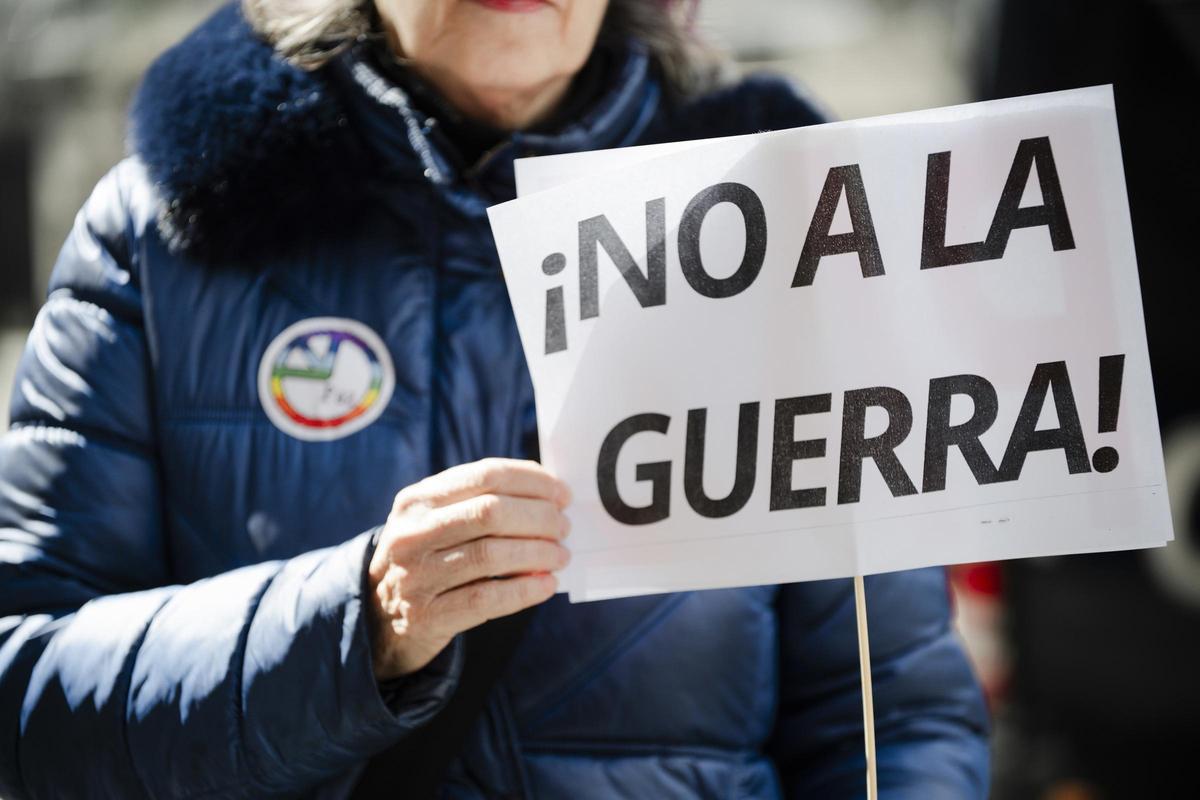 Una personas muestra un cartel de "No a la guerra" en una manifestación.