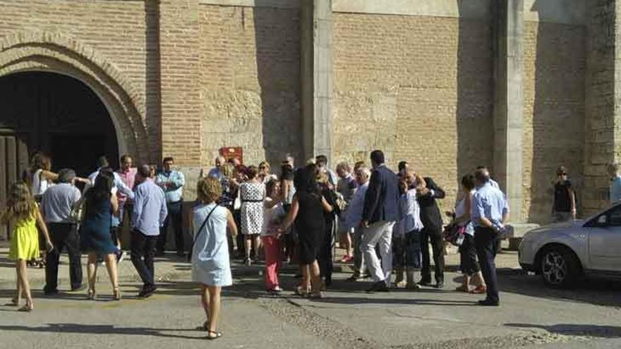 Varias personas expresan sus condolencias a la familia Ballesteros frente a la iglesia de la Santísima Trinidad.