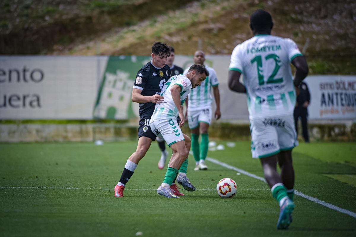Nico Espinosa trabaja para robarle el balón a Luismi.
