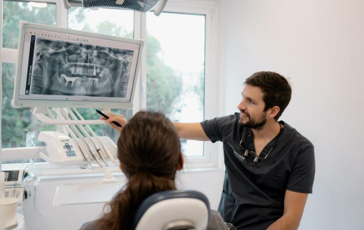 El experto en mplantología con una paciente en su clínica