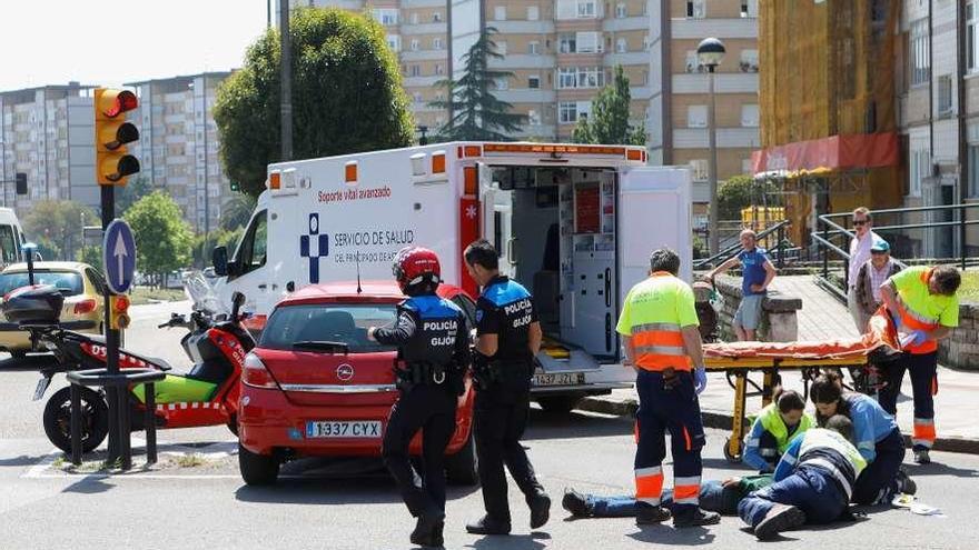 Personal sanitario y agentes de la Policía Local atienden al motorista herido tras colisionar en la calle Severo Ochoa, en el cruce con la avenida de Gaspar García Laviana.