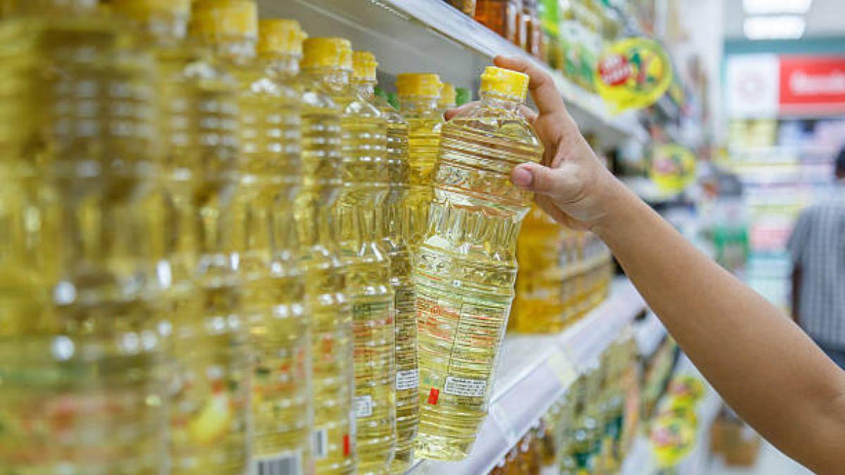 Una persona comprando una botella de aceite