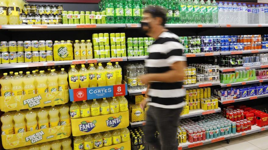 Un hombre pasa frente
a los lineales de refrescos de
un supermercado.  // M.A.M. | FDV