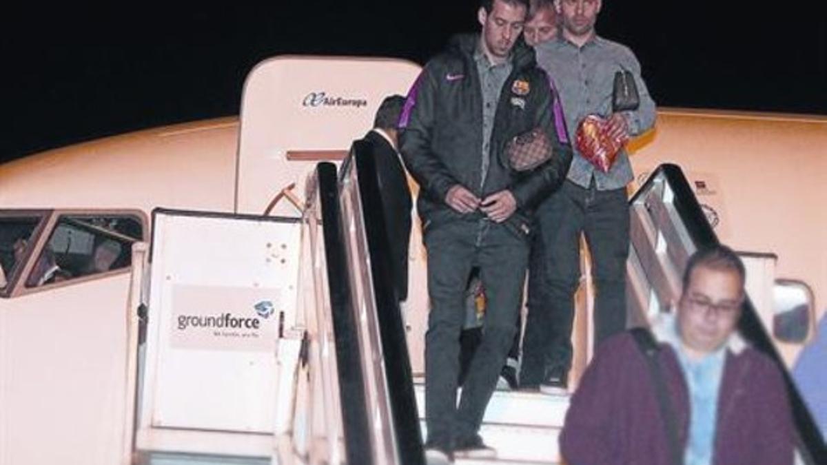 Busquets, delante de Mascherano, al descender del avión el miércoles.