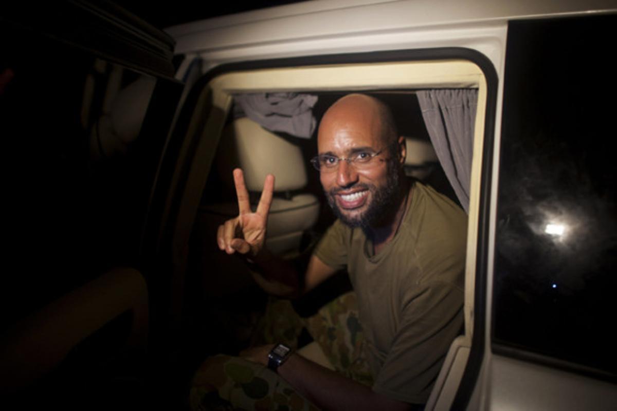 Saïf al-Islam, fill del dictador libi Gaddafi, realitza el gest de la victòria durant la seva reaparició ahir a la nit en els carrers de Trípoli.