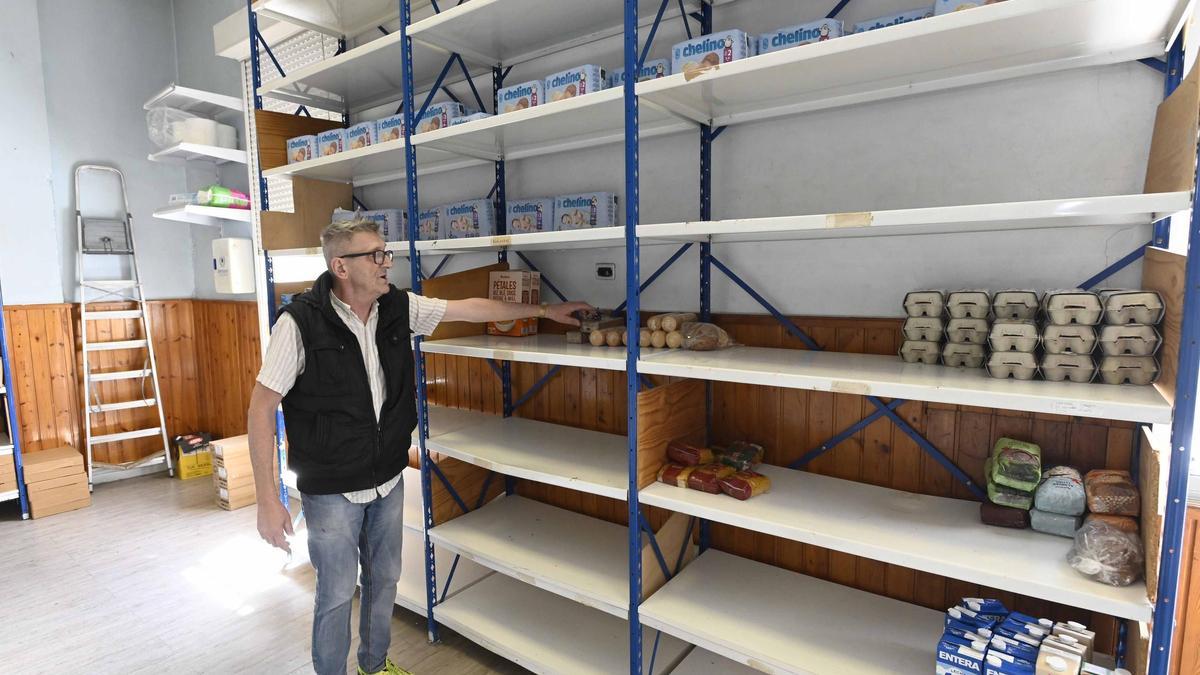 Víctor Pérez, voluntario de AFAN, junto a las estanterías vacías del almacén de la asociación.