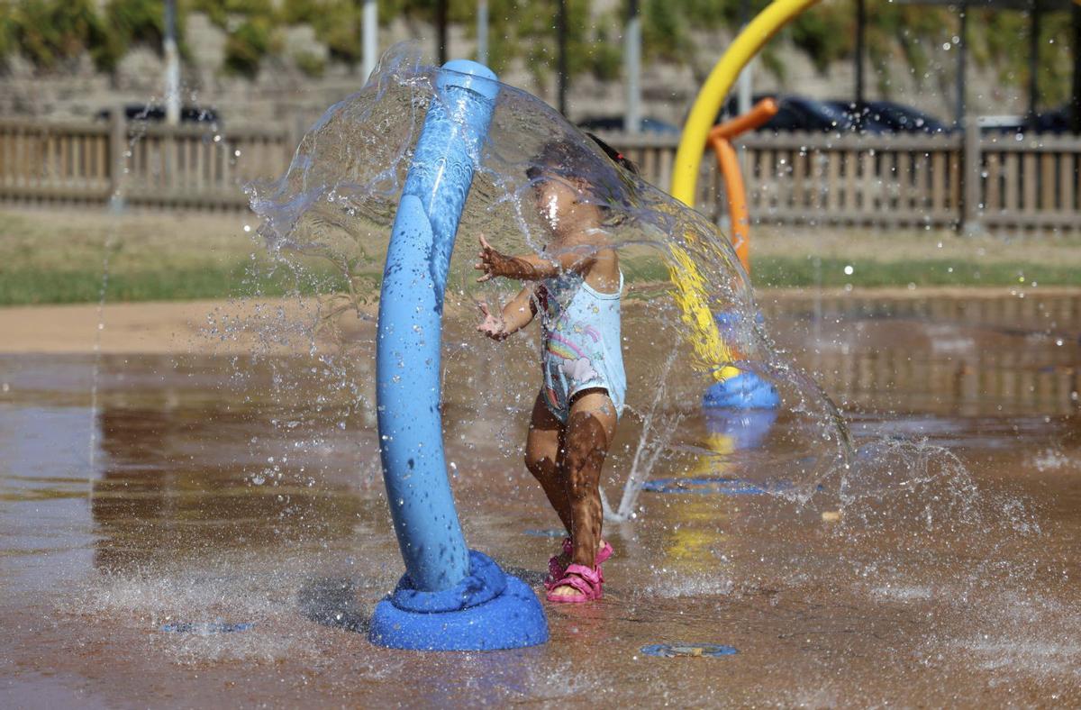 Una niña juega con una fuente en Pontevedra.