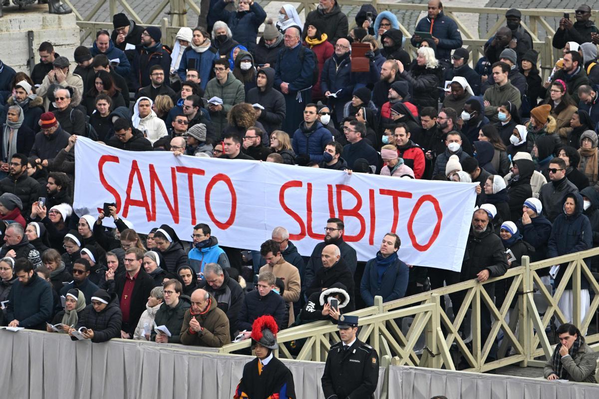 Fieles sostienen una pancarta que dice Santo subito, pidiendo la canonización inmediata del Papa emérito Benedicto XVI .